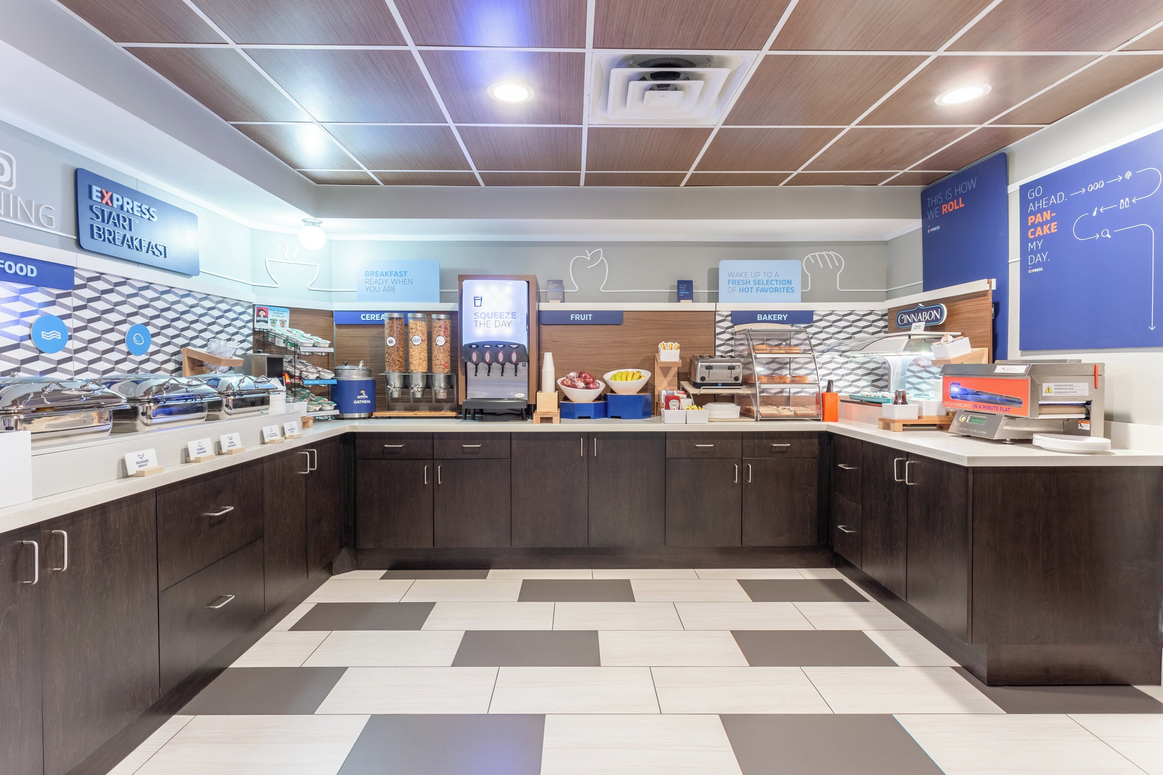 A breakfast area with a self-serve station, cereal, fruit, and bakery options.