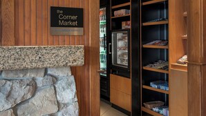 A wooden interior with a stone accent wall, a sign for 'The Corner Market', and shelves stocked with various items.