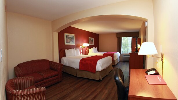 A hotel room with a bed, a desk, a chair, and a sofa. - Ramada by Wyndham Fresno Northwest (Fresno)