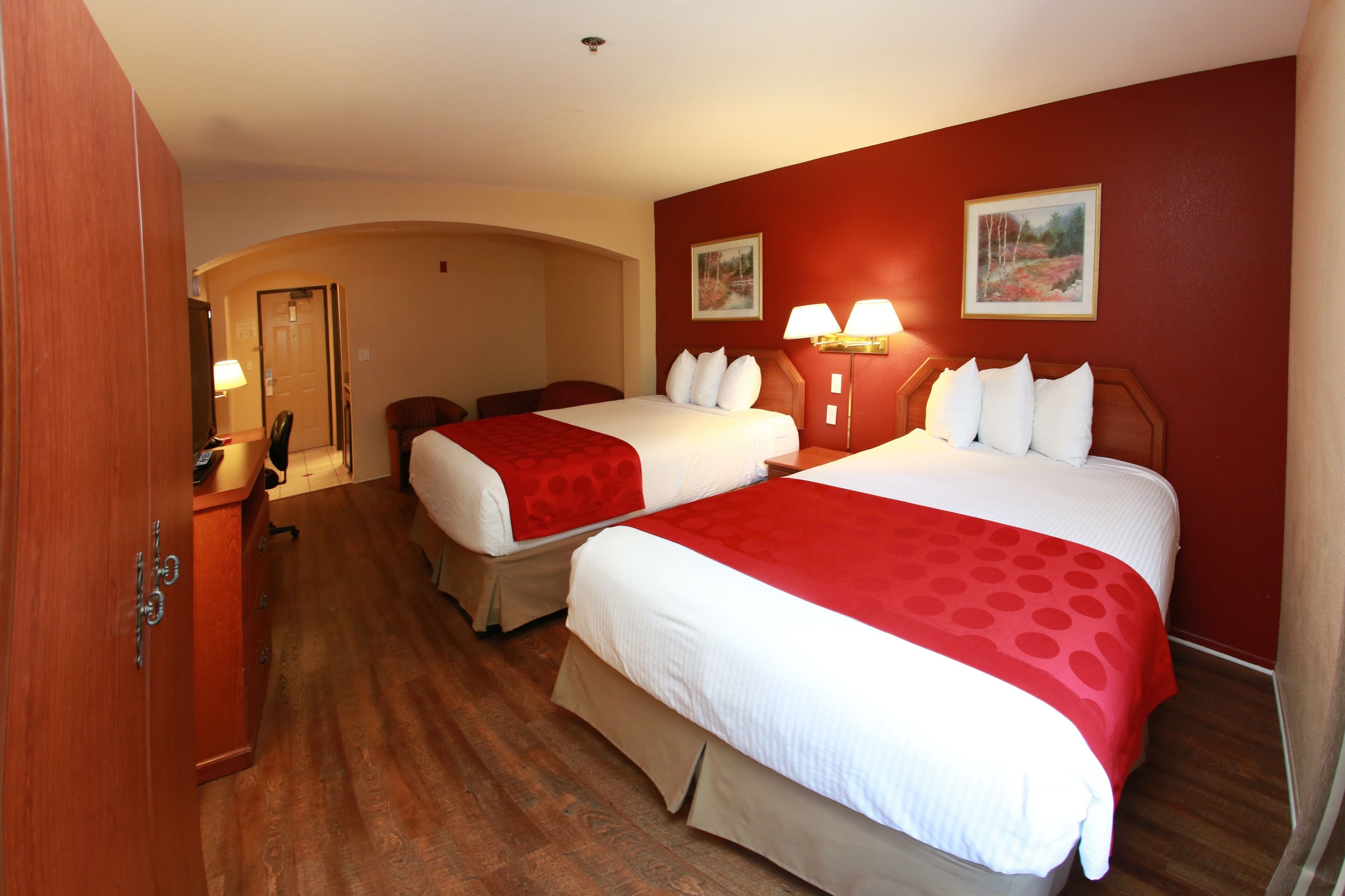 Une chambre d’hôtel avec deux lits, un bureau et une chaise.