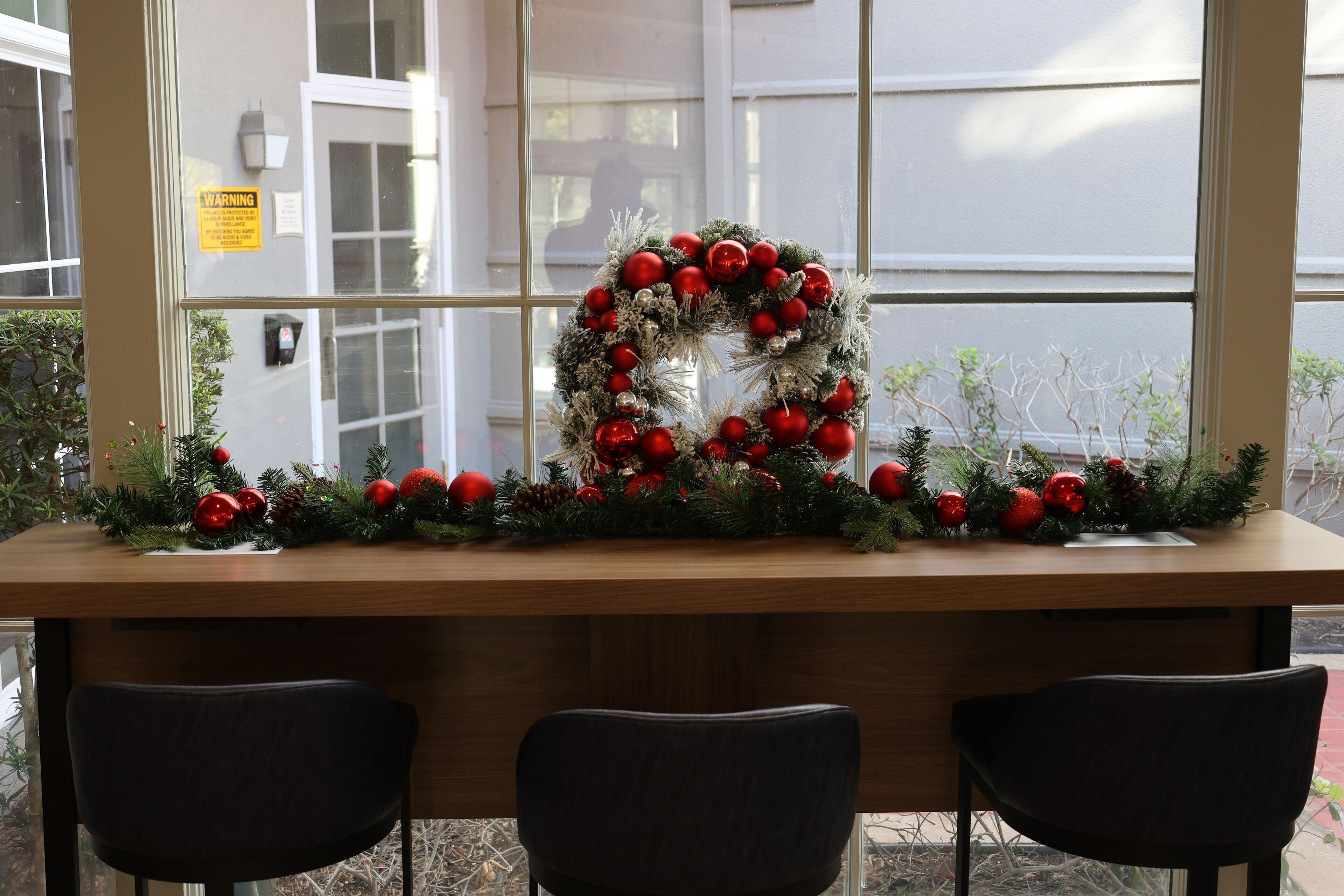 A reception desk with a Christmas wreath and decorations.
