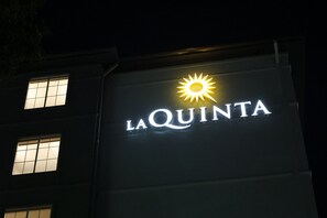 A building with a sign that reads "LA QUINTA" and a sun symbol above the text.