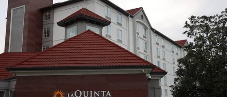 Un hôtel appelé La Quinta, reconnaissable à son toit rouge vif et à son clocher.