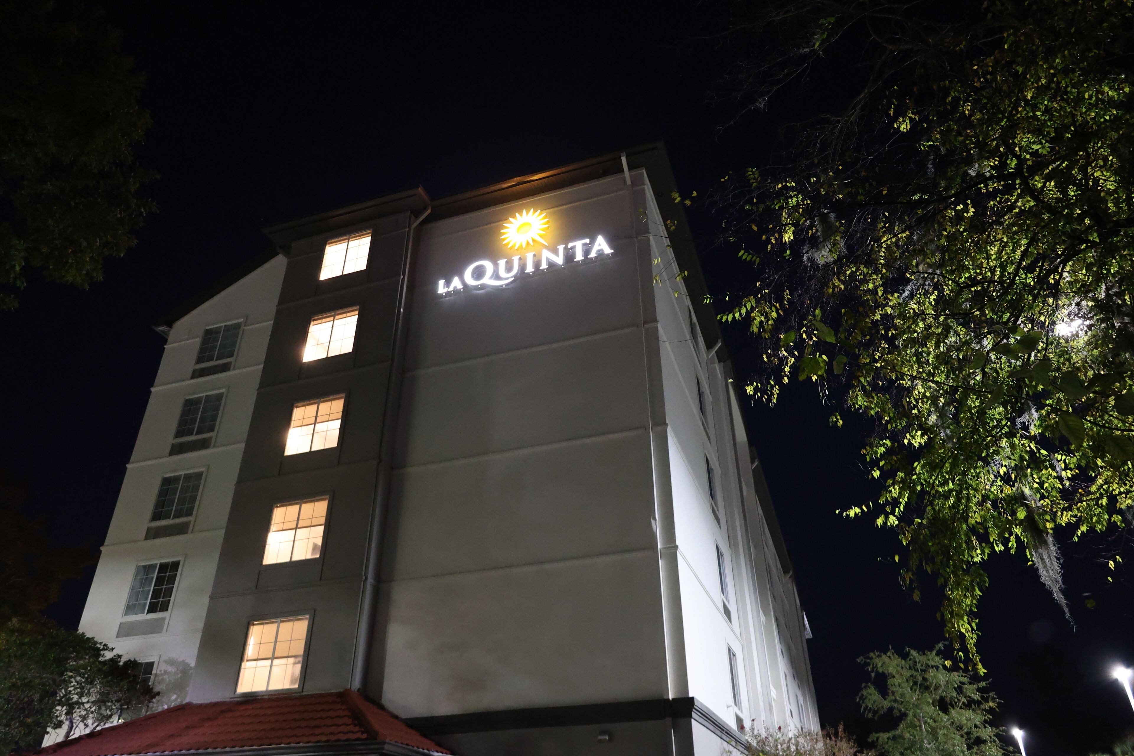 A hotel named La Quinta with illuminated signage at night.