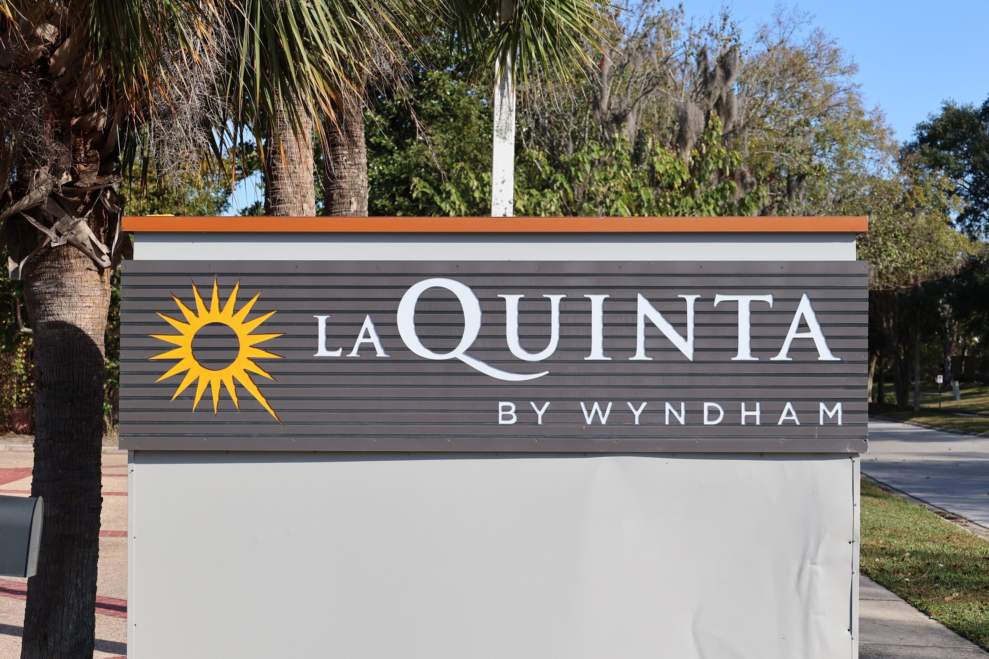 Skilt for La Quinta by Wyndham med et sollogo.