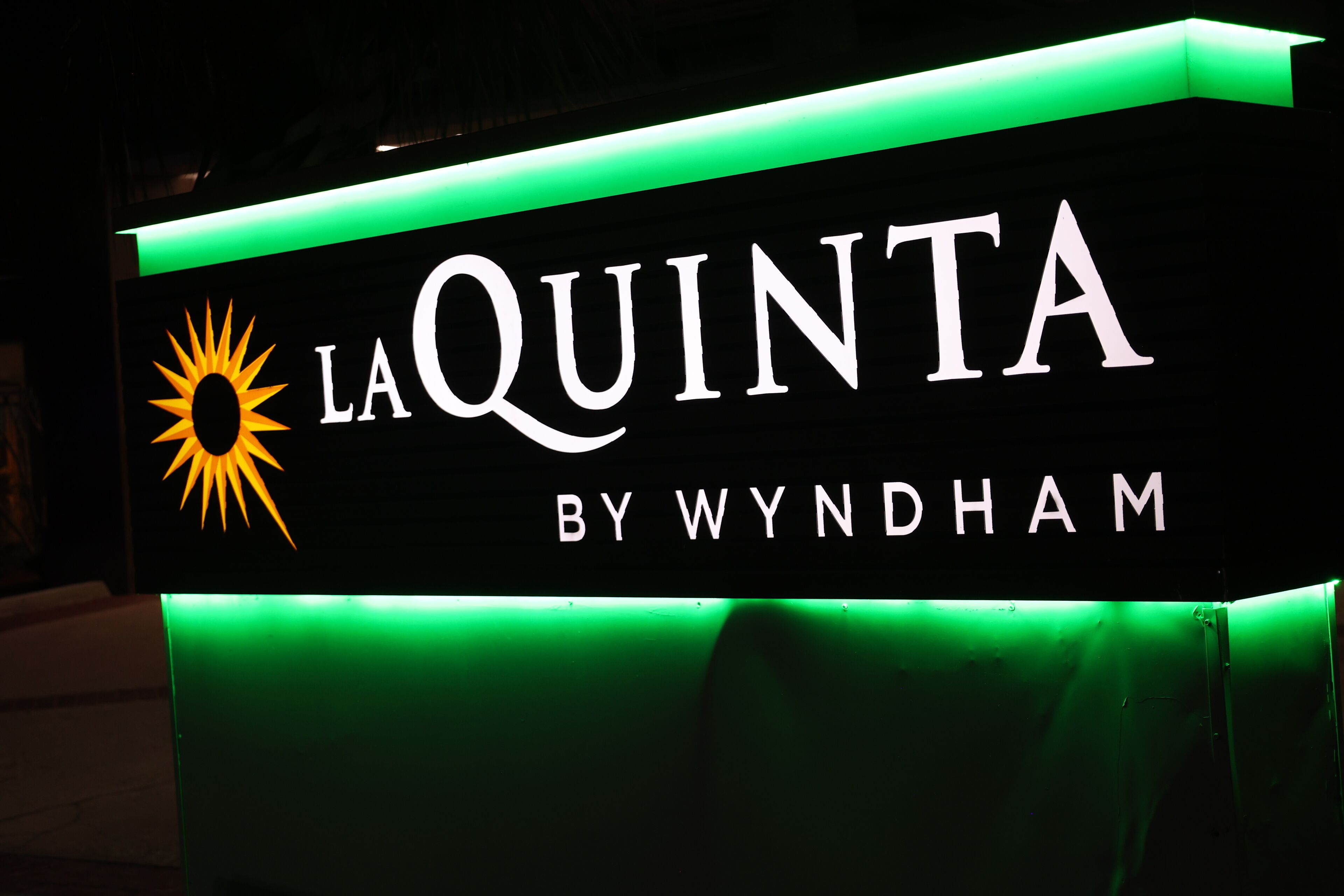 A sign for La Quinta by Wyndham with a sun logo.