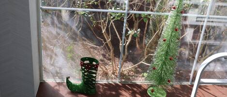 A window sill with a small Christmas tree and a decorative boot.