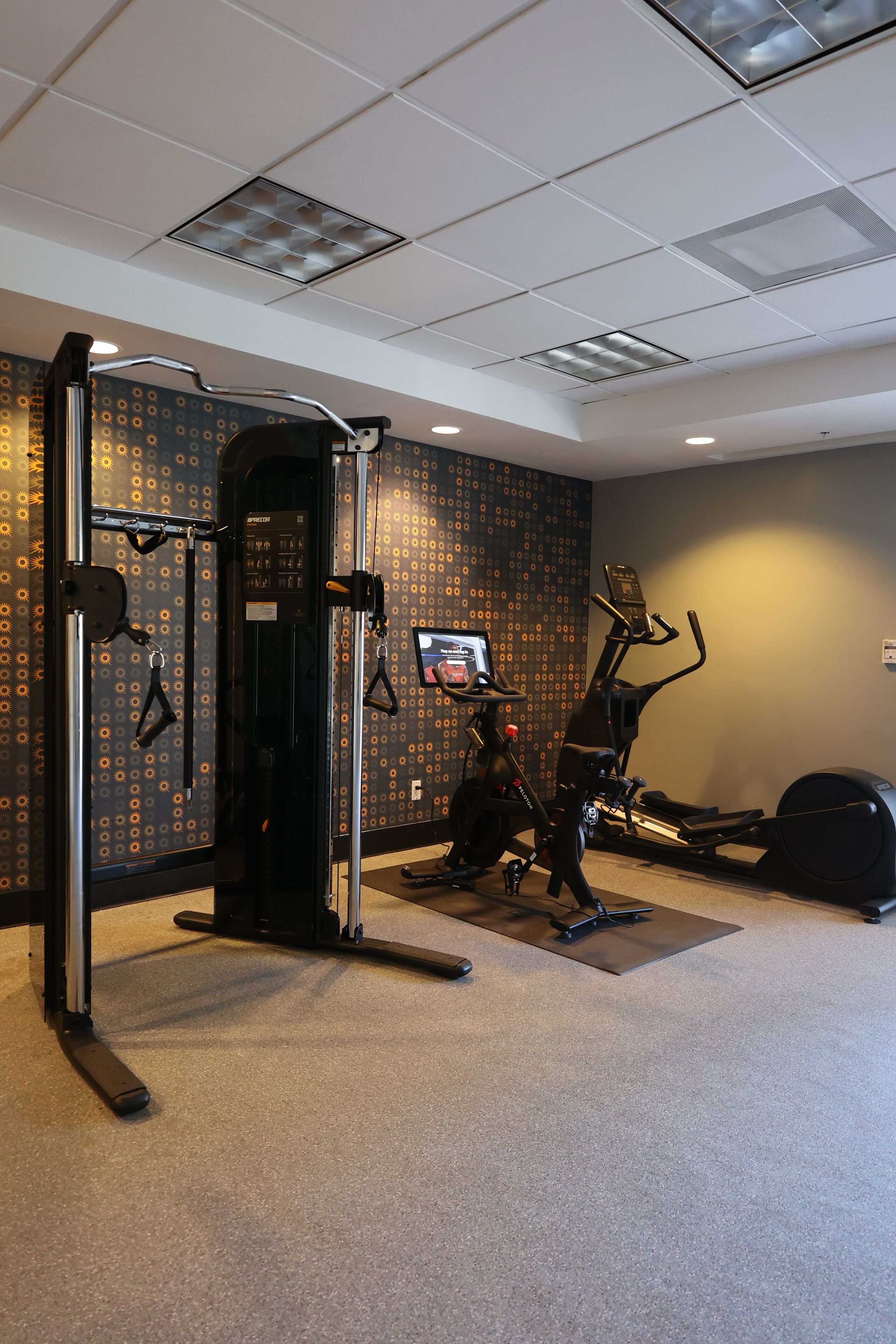 A gym with exercise equipment, including a pull-up bar, an elliptical, and a stationary bike.