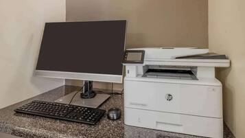 A desktop computer with a monitor, keyboard, and mouse on a granite countertop.