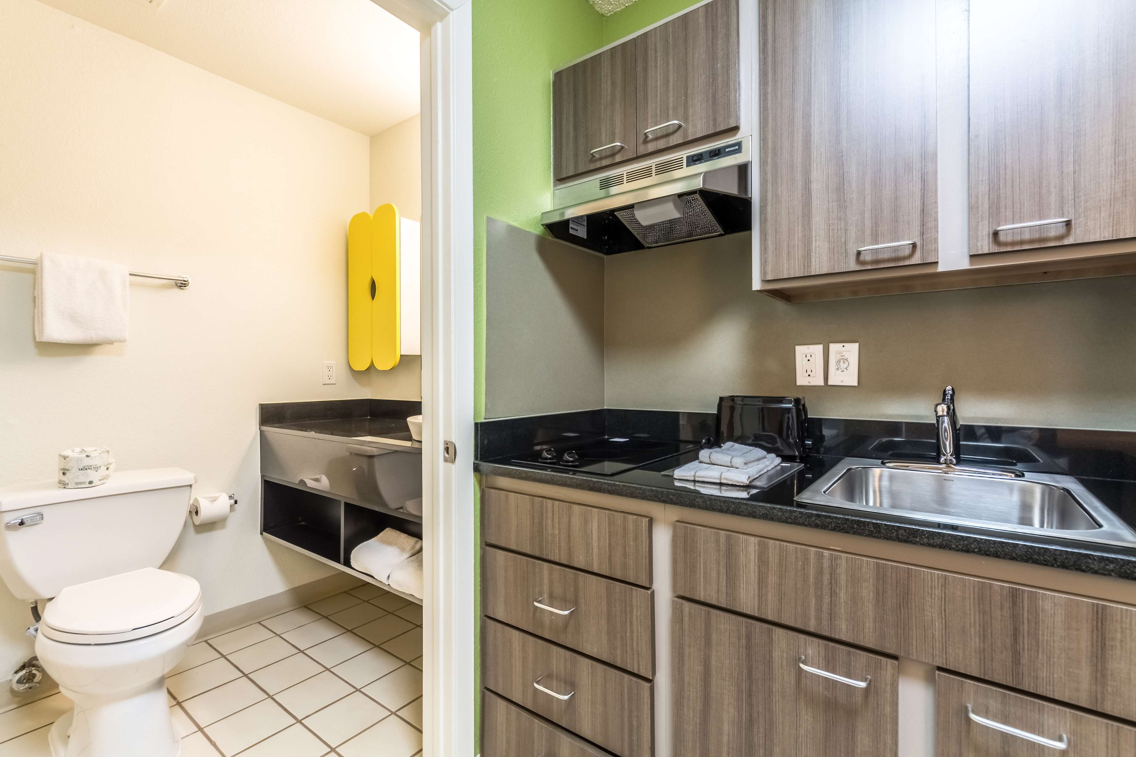 A bathroom with a toilet, sink, and towel rack.