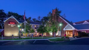 A Marriott Residence Inn with a brick facade, a flagpole, and a well-lit entrance. - Residence Inn by Marriott Hanover Lebanon (Lebanon)