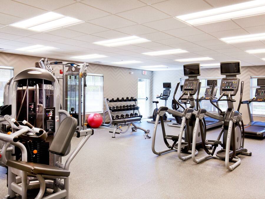 A gym with various exercise equipment, including treadmills, stationary bikes, and weight machines.