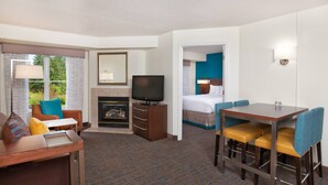 A hotel room with a dining area, a TV, a fireplace, and a bed. - Residence Inn by Marriott Hanover Lebanon (Lebanon)