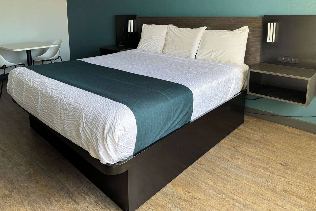 Una habitación de hotel moderna con una cama grande, un escritorio y una silla.