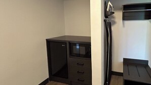 A compact office space with a desk, a chair, and a small shelving unit against the wall. - Studio 6 Suites Gardena, CA (Gardena)