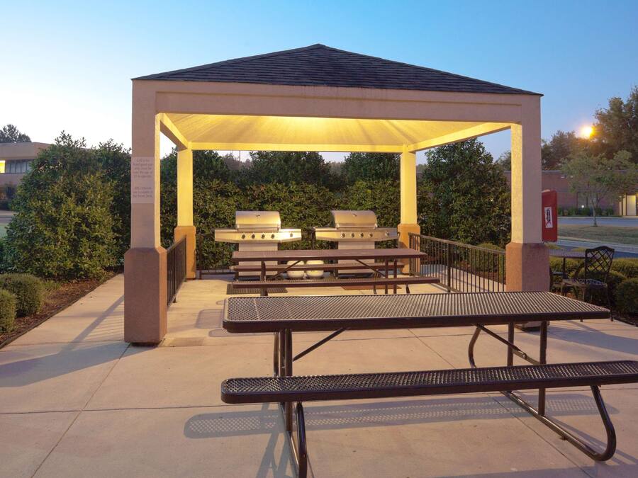 An outdoor pavilion with grilling stations and picnic tables.
