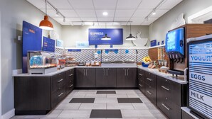 A modern food court with a central island, various food stations, and a yogurt display.