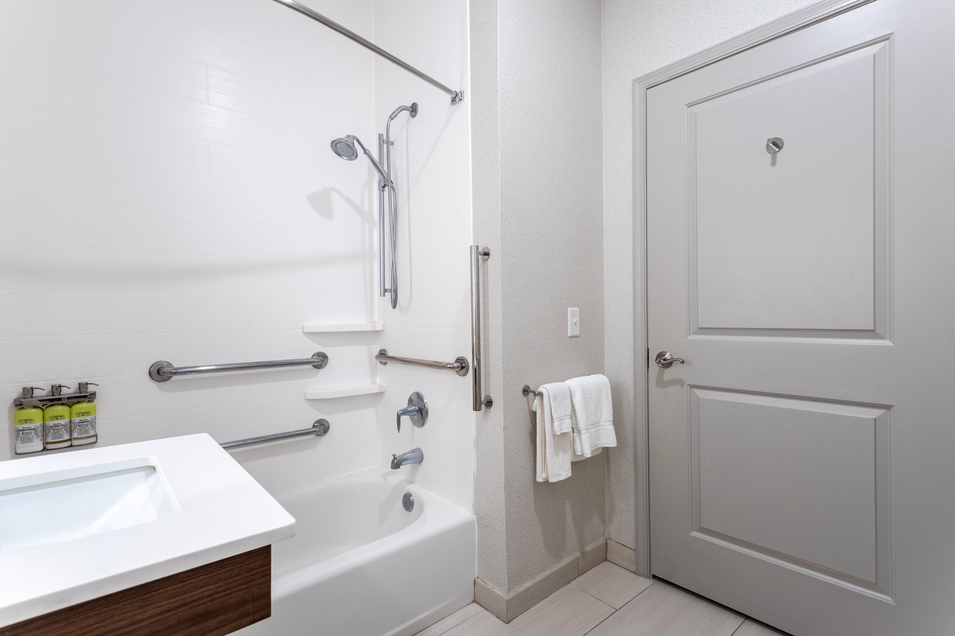 A bathroom with a bathtub, a shower, a toilet, and a door.