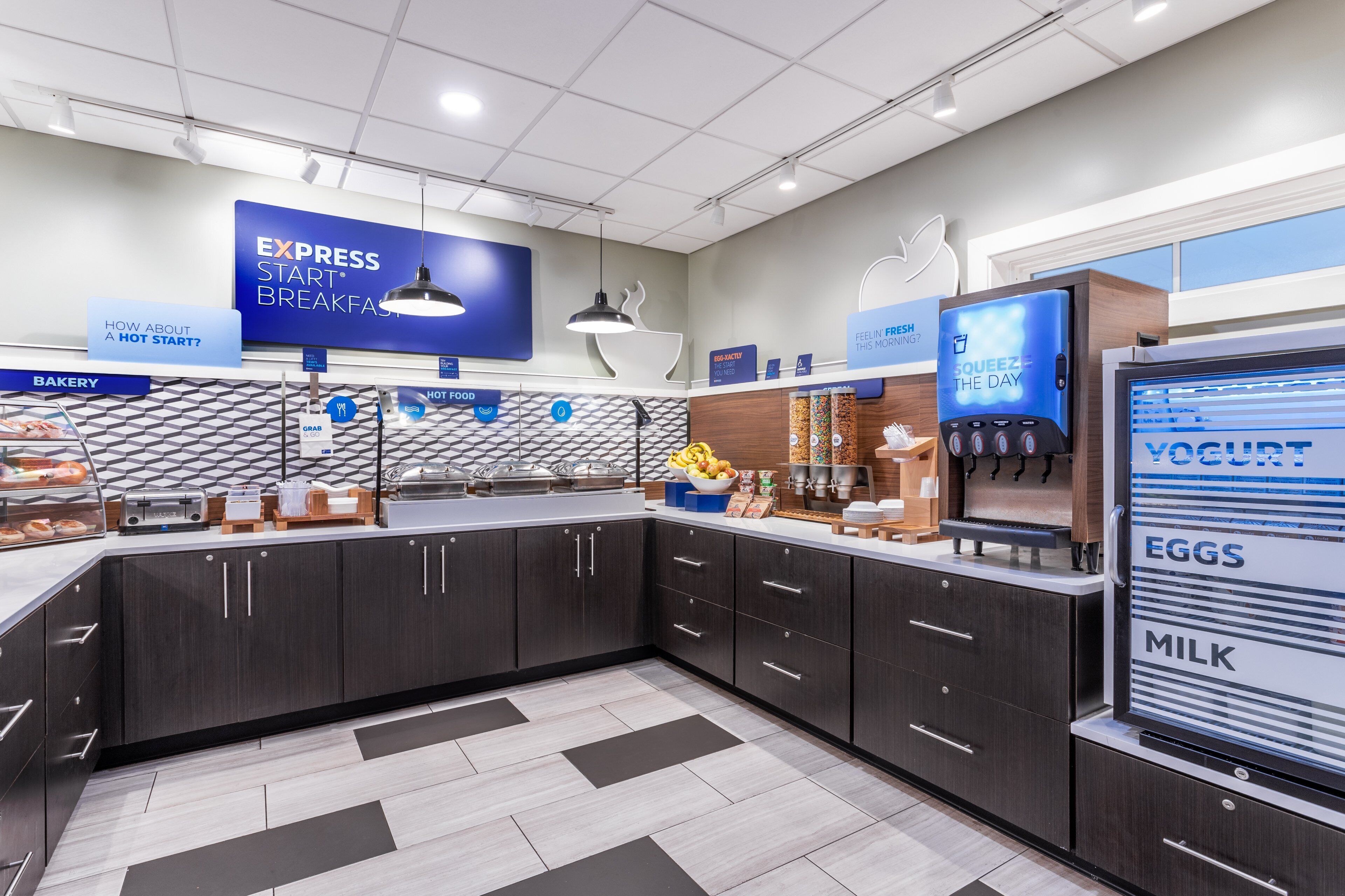 A modern breakfast area with a digital menu board, a yogurt dispenser, and a variety of breakfast items.