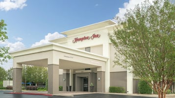 A Hampton Inn hotel with a clear entrance, a sign indicating a clearance of 13 feet, and a welcoming sign.