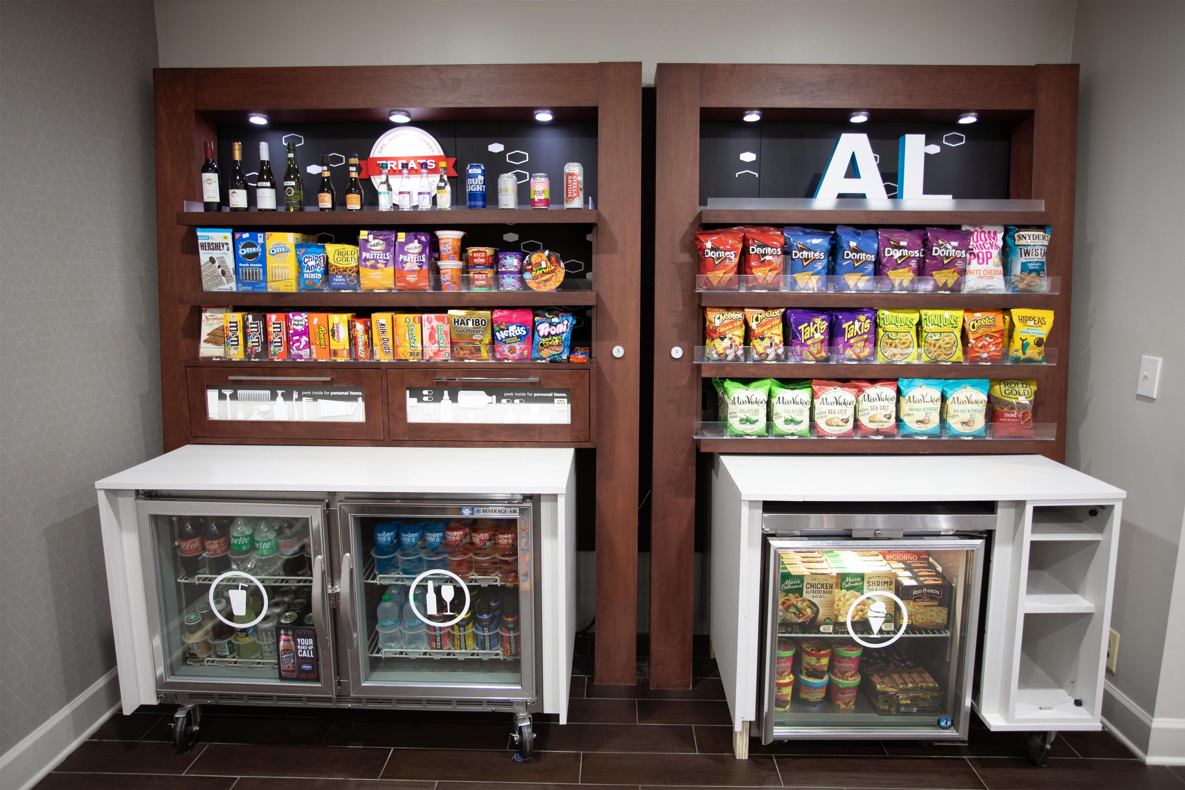 A snack and beverage display with a refrigerator and a freezer.