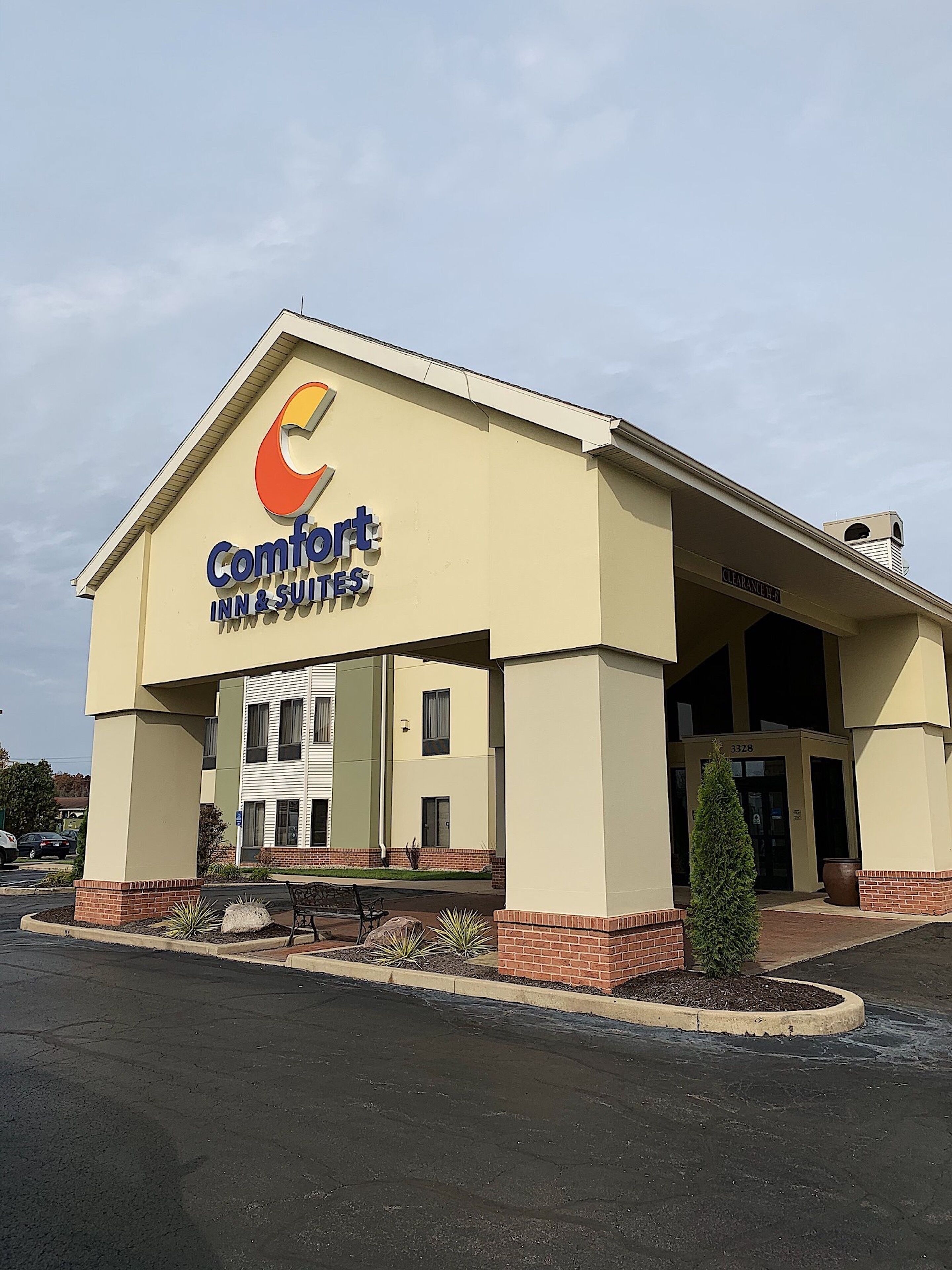 A Comfort Inn & Suites building with a beige exterior, a covered entrance, and a parking lot.