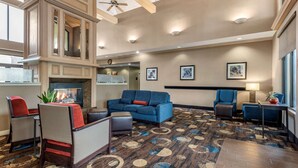 A spacious lobby with a fireplace, comfortable seating, and a patterned carpet.