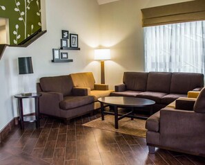 Una sala de estar moderna con un juego de sofá, una mesa de centro y una lámpara.