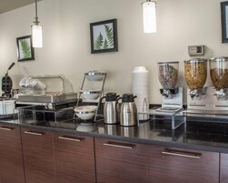 Montaje de bufé con una máquina de café, dispensadores de cereal y un dispensador de leche.