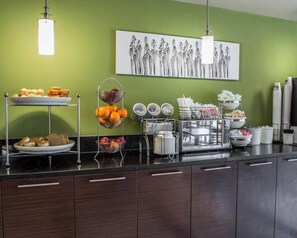 Una barra de desayuno con diferentes alimentos y una estación de café.