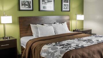 A hotel room with a bed, two bedside tables, and three framed pictures on the wall.