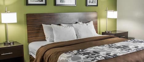 Una habitación de hotel con una cama, dos mesitas de noche y tres cuadros en la pared.