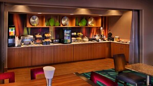 A hotel room with a breakfast bar, wooden cabinets, a refrigerator, and a dining area with a table and chairs. - Springhill Suites by Marriott Mystic Waterford (Quaker Hill)