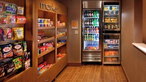 A small, well-organized snack and beverage kiosk with various packaged snacks, drinks, and condiments. - Springhill Suites by Marriott Mystic Waterford (Quaker Hill)