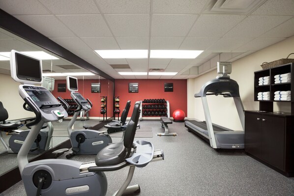 A gym with treadmills, elliptical machines, and free weights.