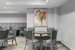 A dining area with a table and chairs, a ceiling light, and a painting on the wall. - Homewood Suites by Hilton Williamsburg (Williamsburg)
