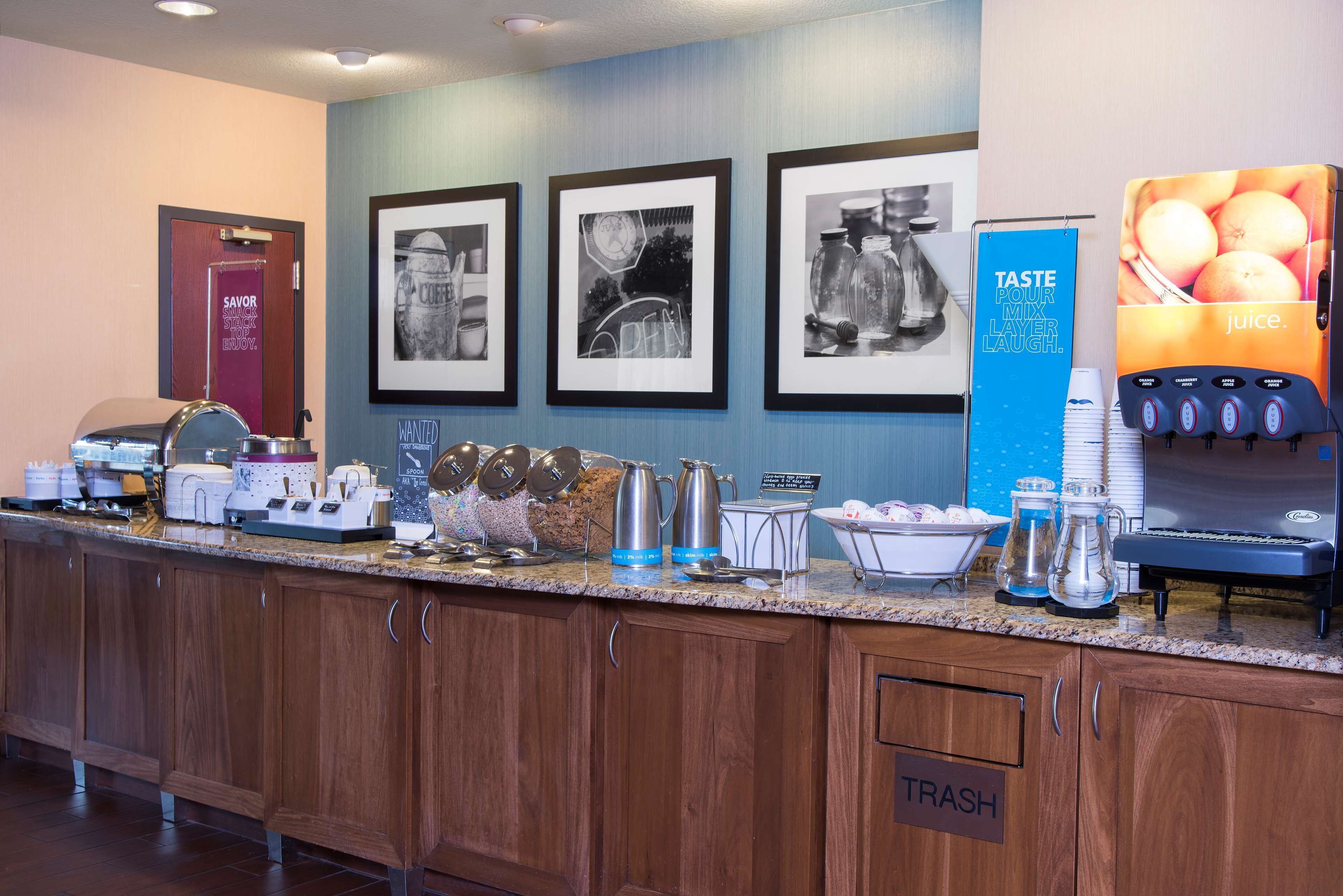 Un espace buffet comprenant un coin café, un distributeur de jus et une poubelle.