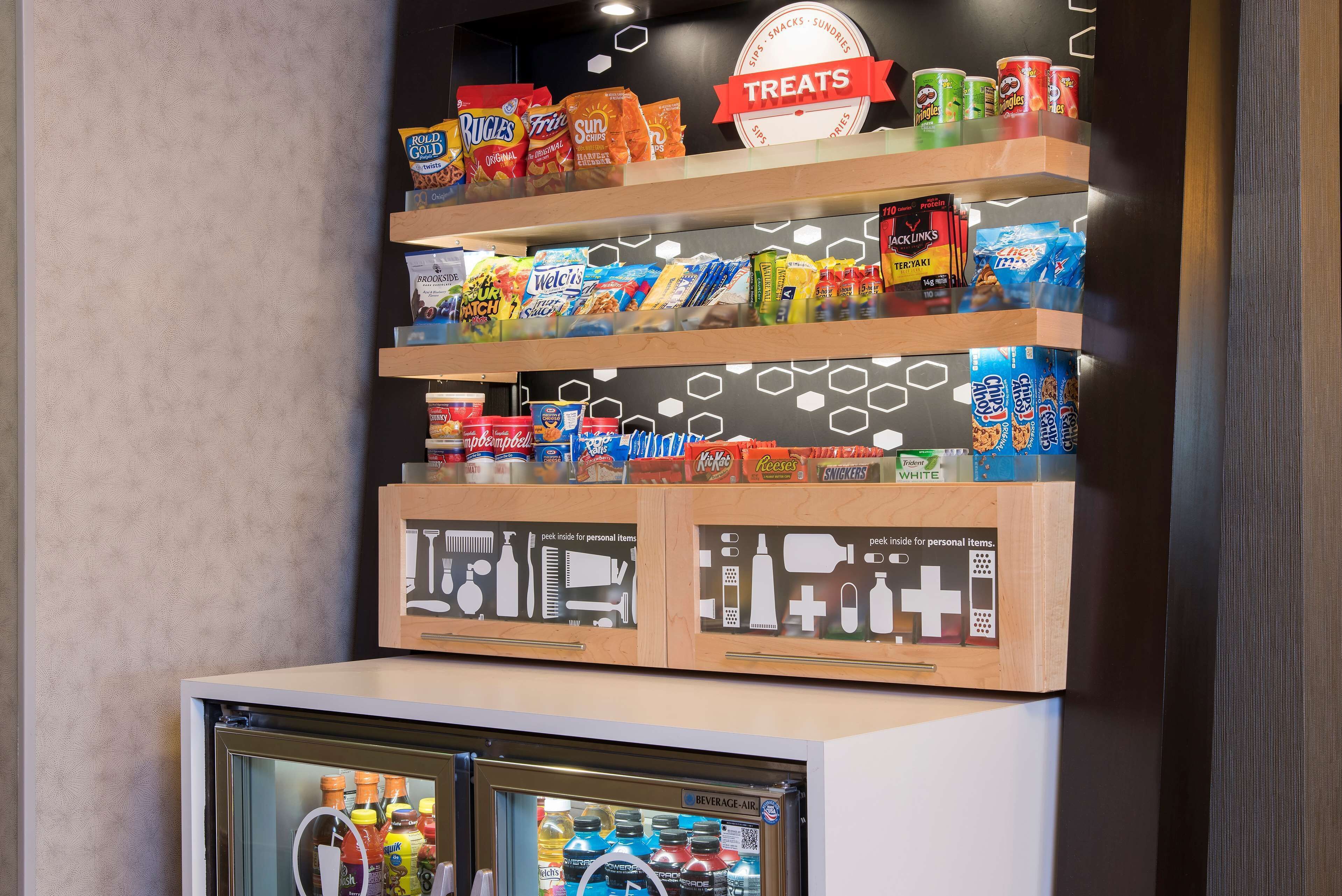 A snack display with various brands and a refrigerated section below.