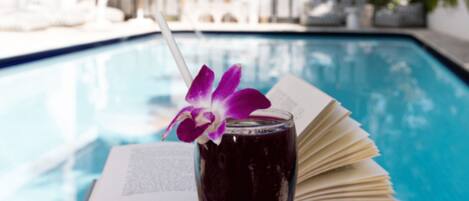 Alberca al aire libre, sombrillas en la alberca y camastros