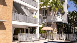 Ein Hotel mit Pool, mehreren Balkonen und Palmen.