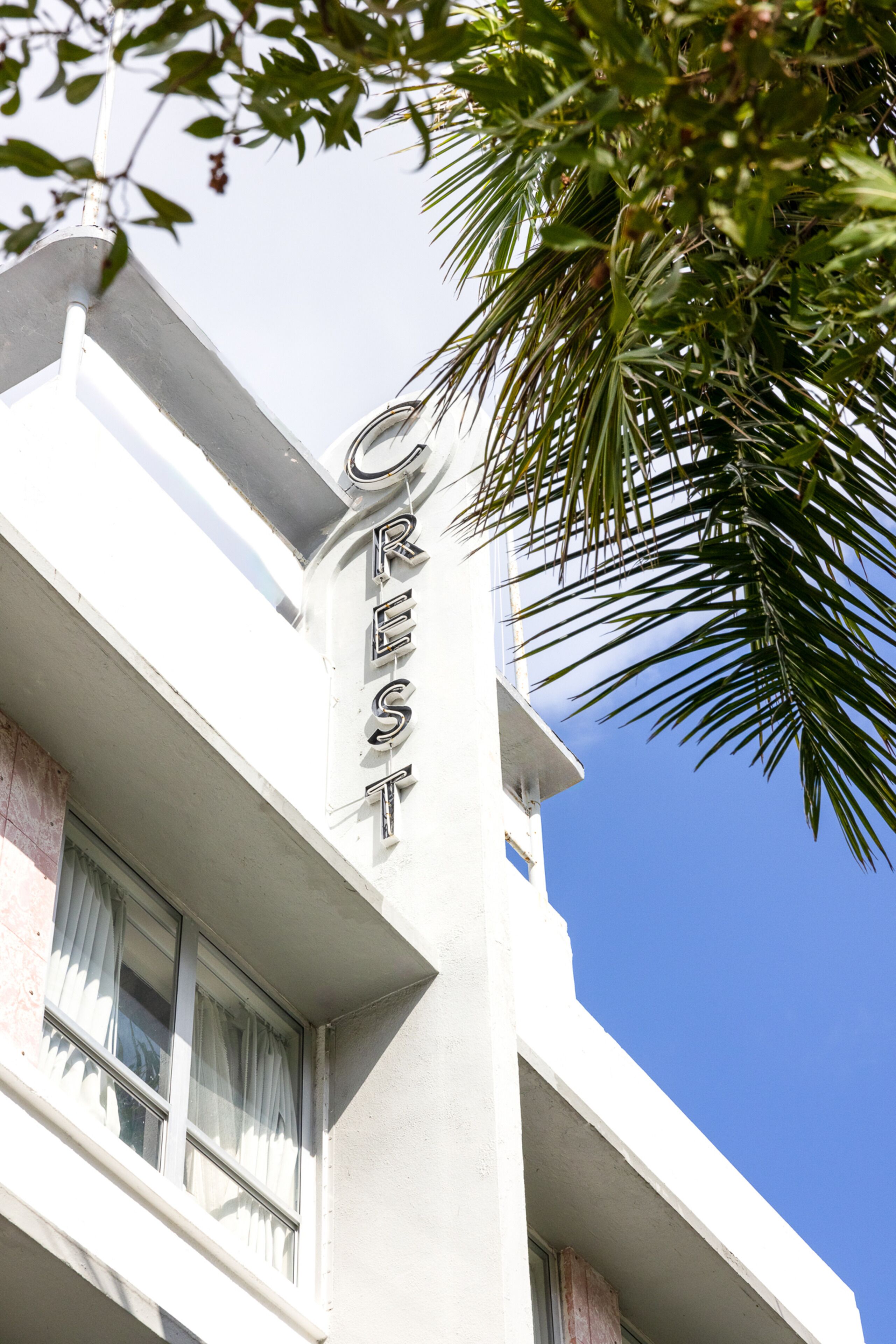 A building with a sign reading "CREST" on the corner.