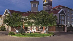 Un hôtel La Quinta, reconnaissable à son enseigne en forme de tour imposante, à sa pelouse bien entretenue et à son entrée sécurisée par un portail.