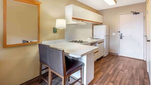 A compact kitchen with a dining area, a built-in oven, and a refrigerator.