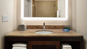 A bathroom with a granite countertop sink, a mirror, a towel rack, and a towel dispenser. - Holiday Inn Express Suites Belmont by IHG (Belmont)