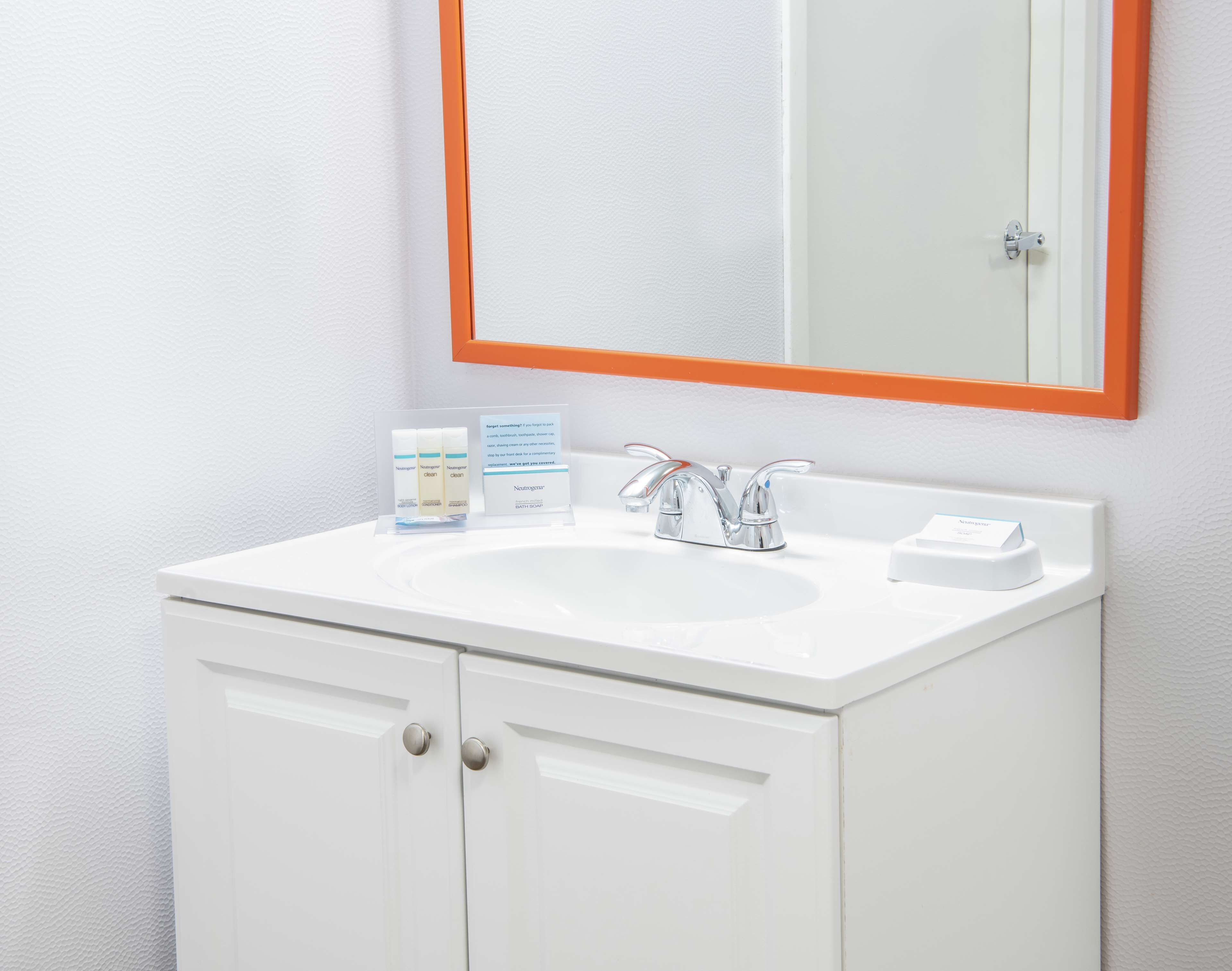 A white bathroom vanity with a mirror, a sink, and a cabinet.