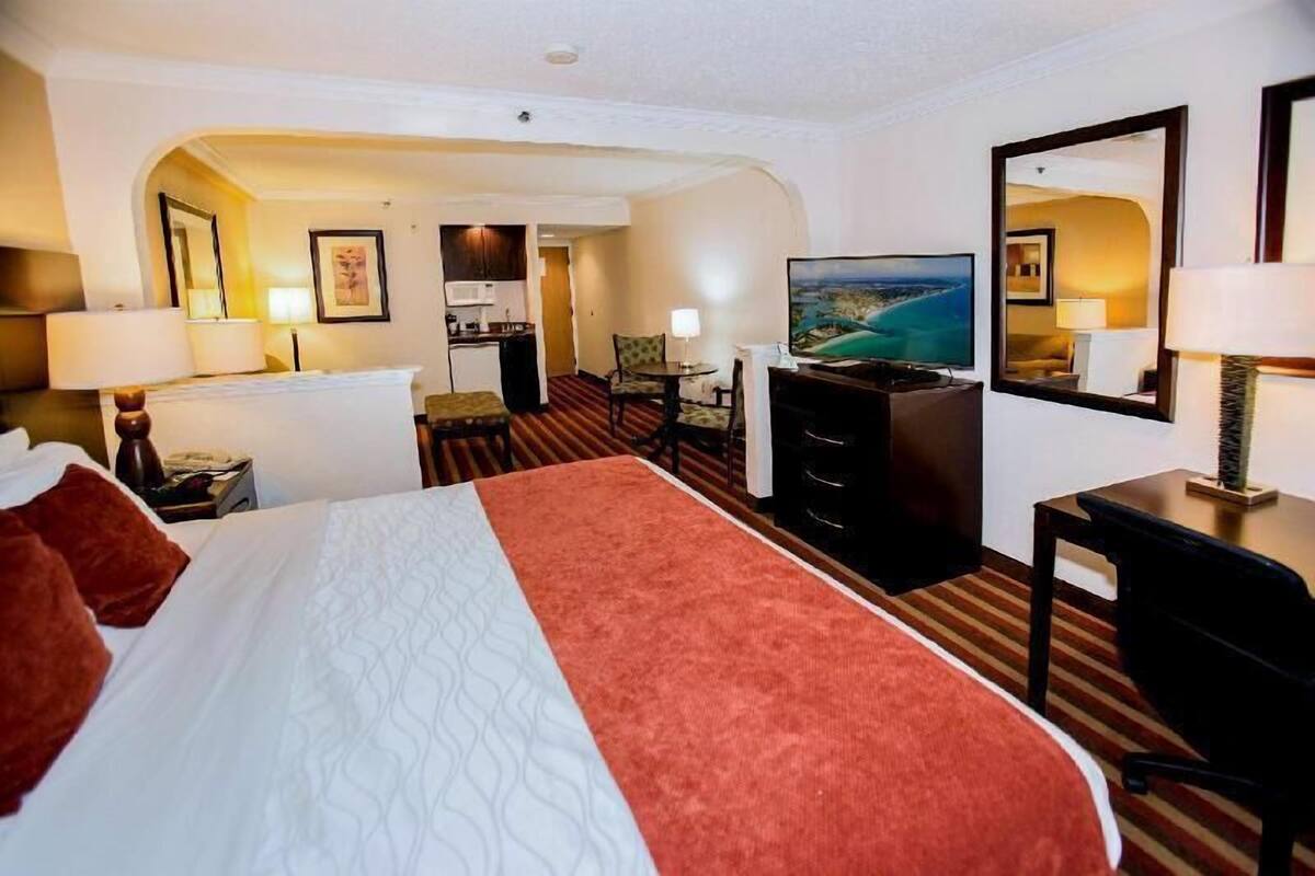 Une chambre d’hôtel comprenant un lit, un bureau, une télévision et un coin repas.