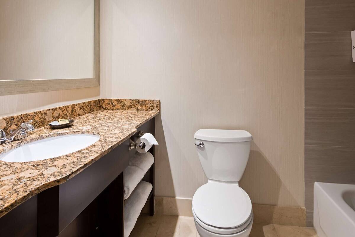 Une salle de bain avec deux lavabos, des toilettes et une baignoire.