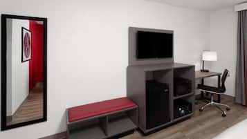 A hotel room with a flat-screen TV mounted on a wooden cabinet, a desk with a lamp, a black office chair, a red bench, and a microwave.