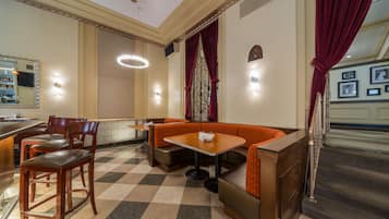 Un restaurante con piso a cuadros, muebles de madera y cortinas rojas.