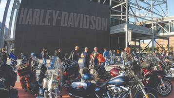 A Harley-Davidson building with a large sign, surrounded by a crowd of people and numerous motorcycles.